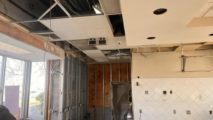A kitchen ceiling and walls opened to the framing for drying