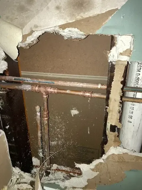 A wall opened up to reach leaking copper supply lines
