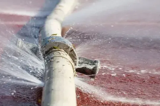 Water spraying from a pipe that burst inside a wall