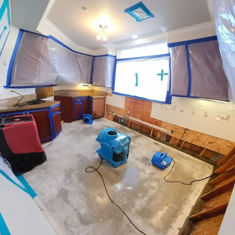 Containment, air movers and a dehumidifier drying a stripped-out kitchen